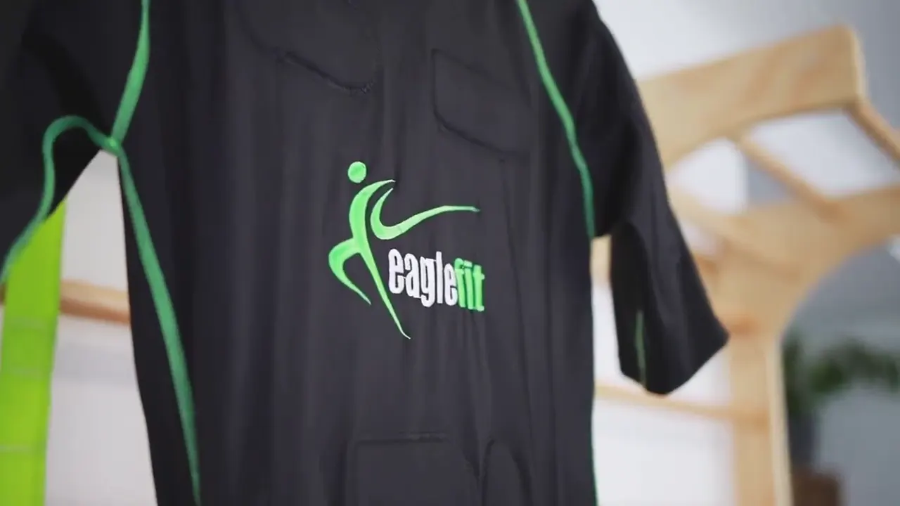 Nahaufnahme des schwarzen EMS-Anzugs mit grünen Nähten und eaglefit-Logo